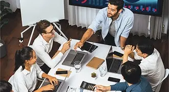 Team of professionals discussing project around laptops and notebooks