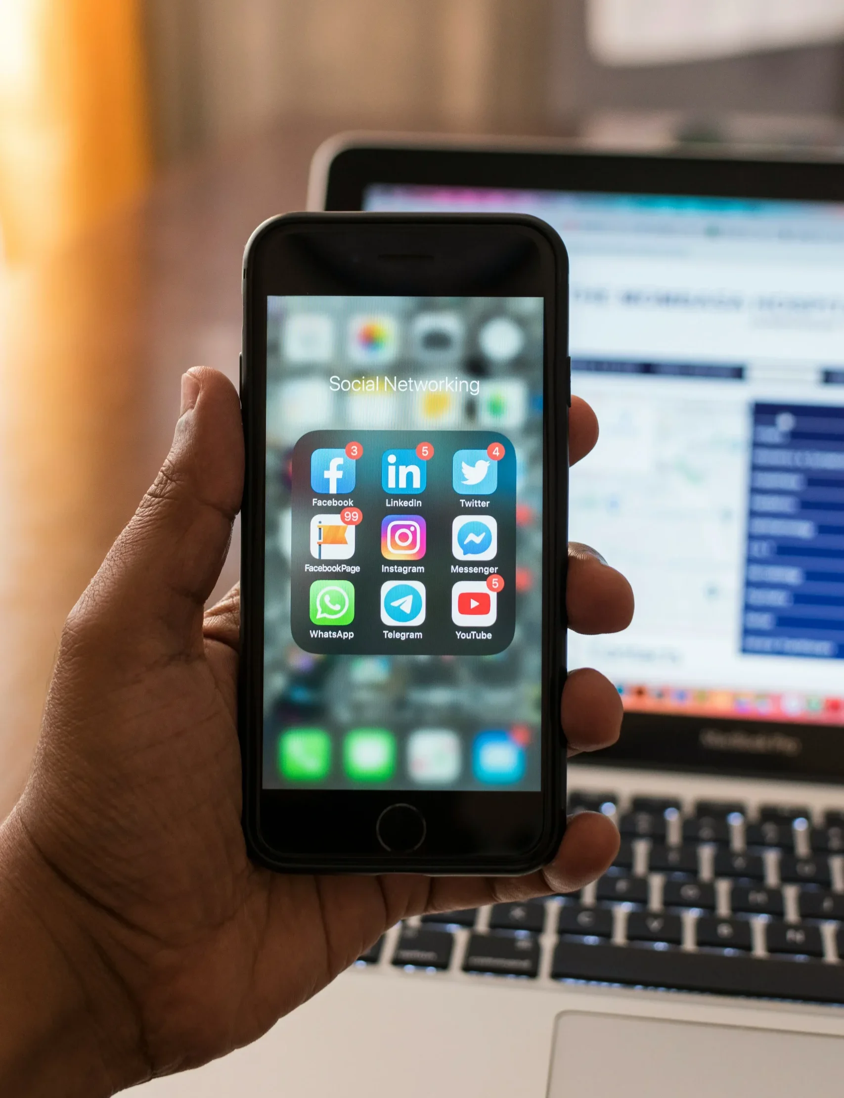 Person holding smartphone showing app icons on screen